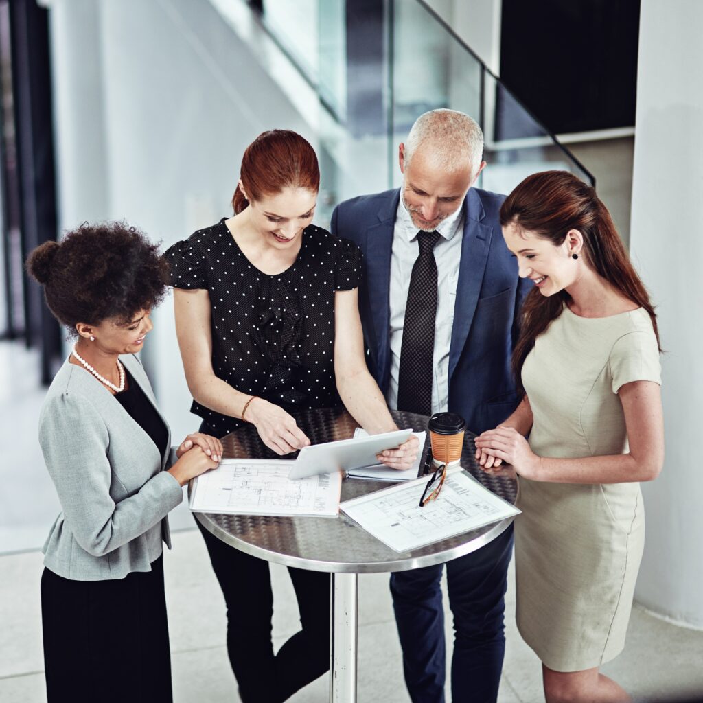 Shot of a corporate business team using a digital tablet together in a meeting at work