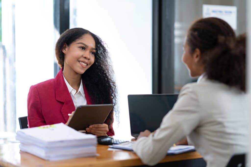 Two young African businesswomen are sitting and talking. Consulting business information showing res